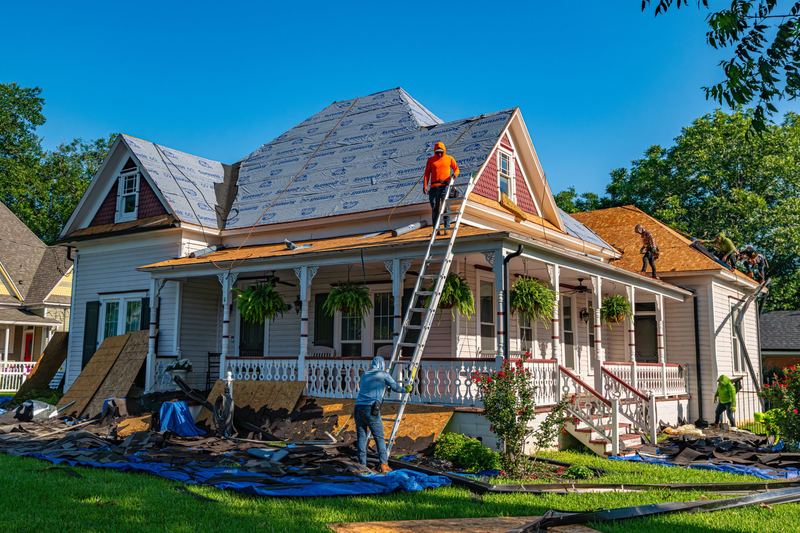 Roofers replacing the roof on a historic home